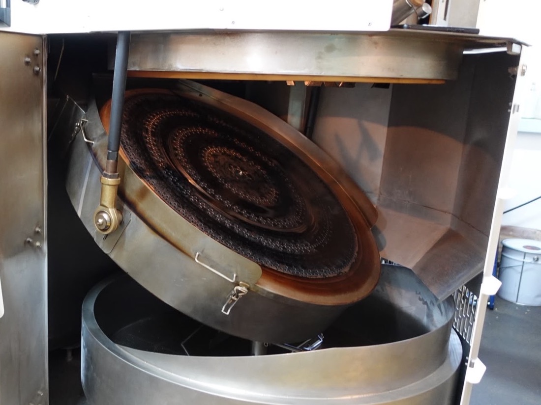 Wooden Hill's roasting machine opened up, showing its perforated copper plate