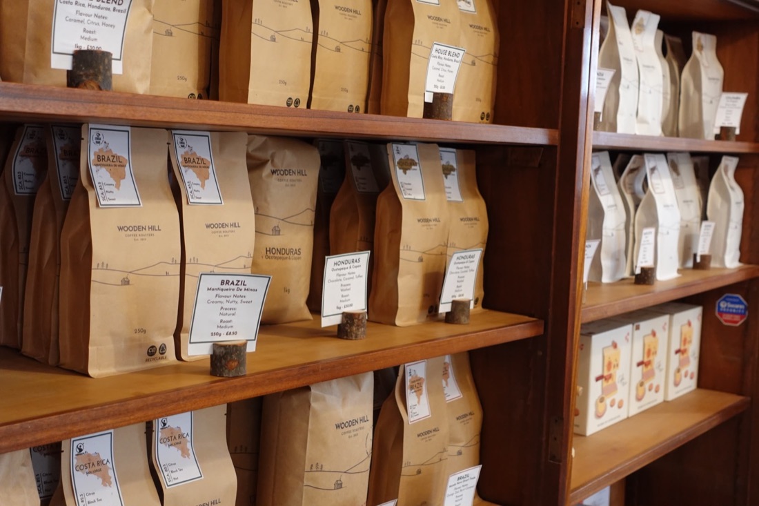 Shelves of Wooden Hill coffee bags with origin cards for Brazil, Honduras and Costa Rica